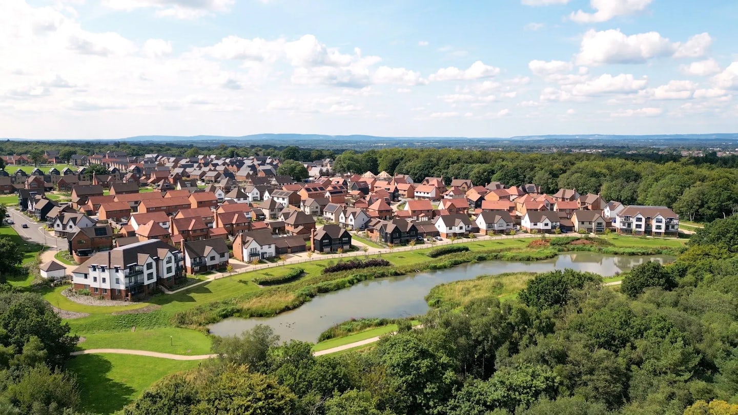 Aerial view of Woodgate homes and landscaped lake at Pease Pottage